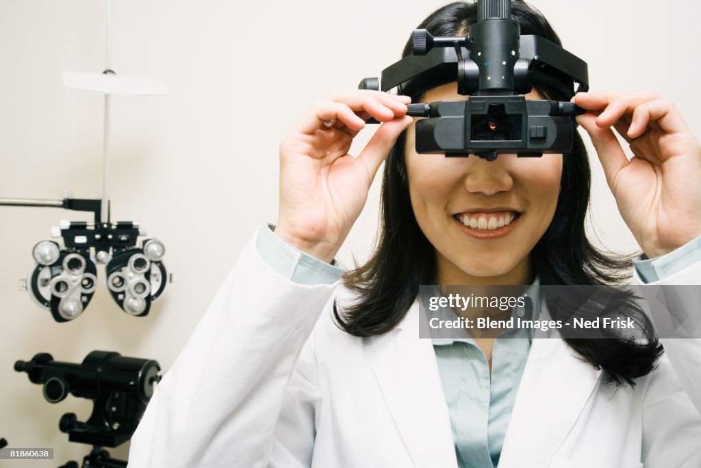 Asian female optometrist wearing examination equipment