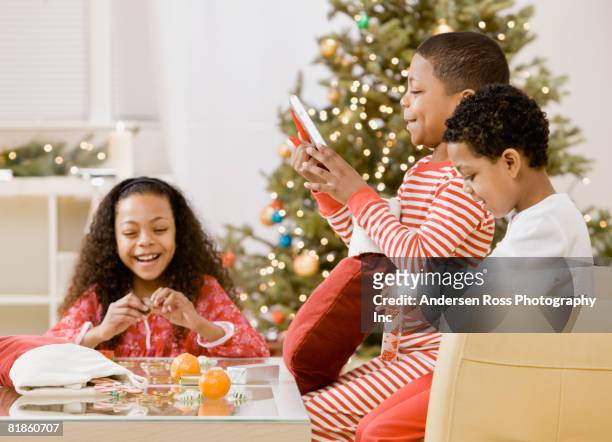 mixed race siblings opening christmas gifts - christmas morning stock pictures, royalty-free photos & images