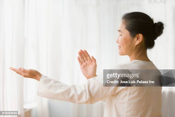 asian woman practicing tai chi - tai chi stock pictures, royalty-free photos & images