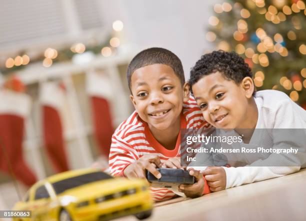 mixed race brothers playing with remote control car - car remote toy stock pictures, royalty-free photos & images