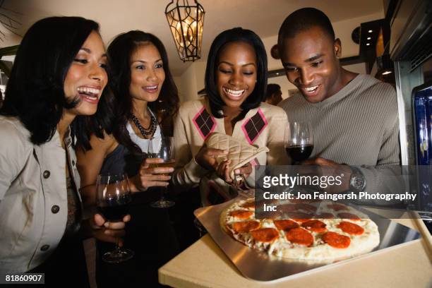 multi-ethnic friends cooking pizza - hot filipina women stock pictures, royalty-free photos & images