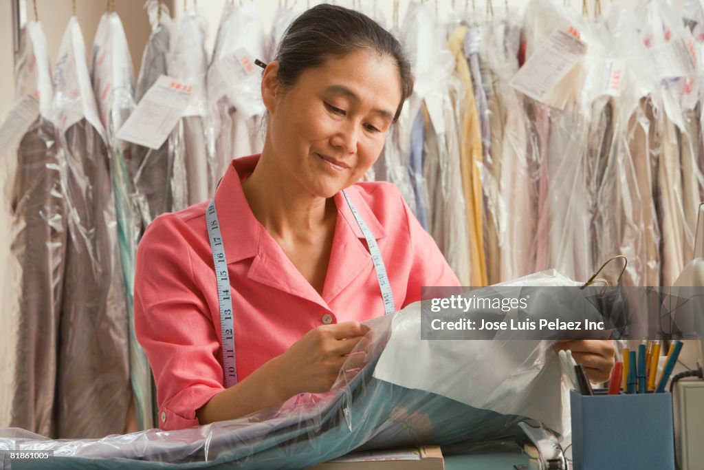 Asian female dry cleaner checking ticket