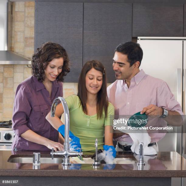 hispanic family washing dishes - kids with cleaning rubber gloves 個照片及圖片檔