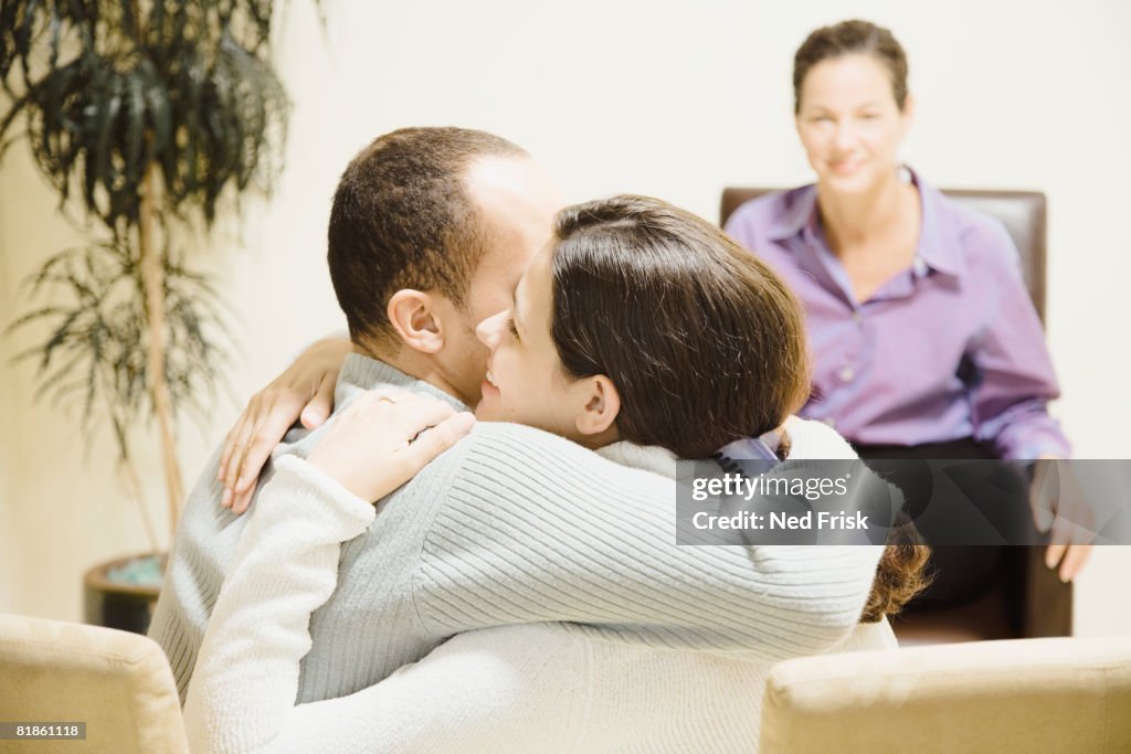 Multi-ethnic couple hugging at therapy session