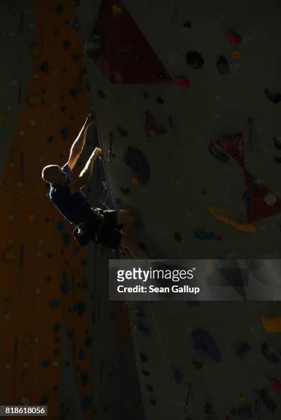 Climber ascends the face of a climbing wall in an indoor facility of the German Alpine Club Berlin chapter on July 18, 2017 in Berlin, Germany. The...