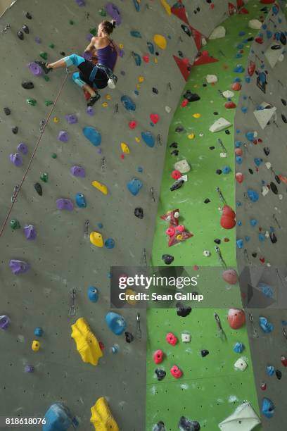 Climber ascends the face of a climbing wall in an indoor facility of the German Alpine Club Berlin chapter on July 18, 2017 in Berlin, Germany. The...