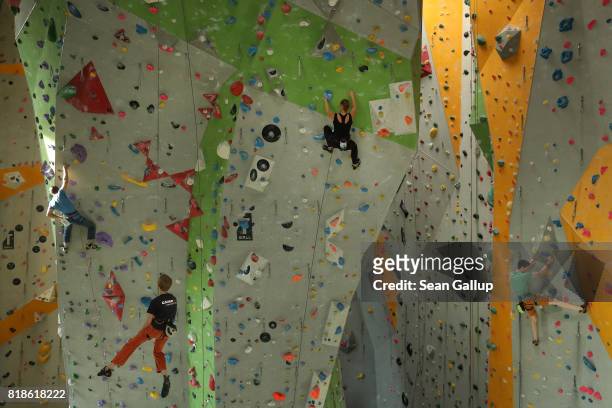 Climbers ascend the faces of a climbing wall in an indoor facility of the German Alpine Club Berlin chapter on July 18, 2017 in Berlin, Germany. The...