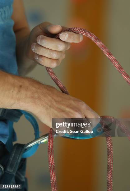 Climber uses a pulley system to counter balance and secure a partner ascending the face of a climbing wall in an indoor facility of the German Alpine...