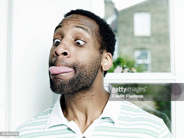 portrait of man poking his tongue out - sticking out tongue stock pictures, royalty-free photos & images