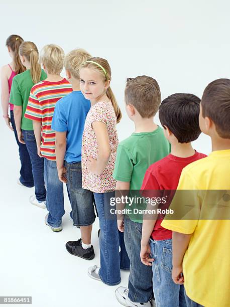 group of children standing in a line, one girl looking around - child waiting stock pictures, royalty-free photos & images