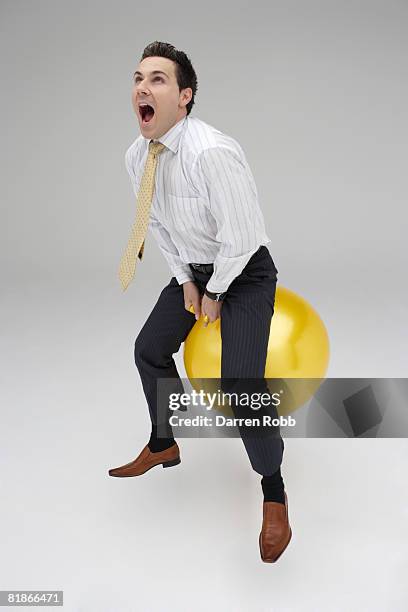 businessman riding on a space hopper, screaming - screaming man looking up stock-fotos und bilder