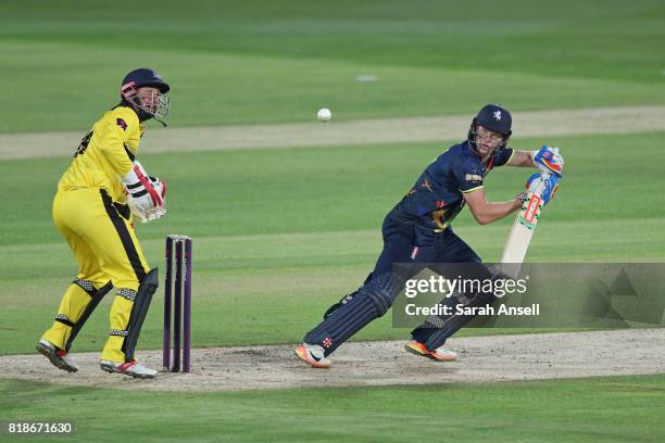 Sam Billings of Kent Spitfires hits out as Gloucestershire wicket keeper Phil Mustard looks on during the NatWest T20 Blast South Group match at The...