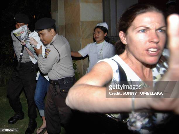 Mercedes Corby tries to protect her sister convicted drug trafficker Schapelle Corby from photographers taking photos as the latter was being...