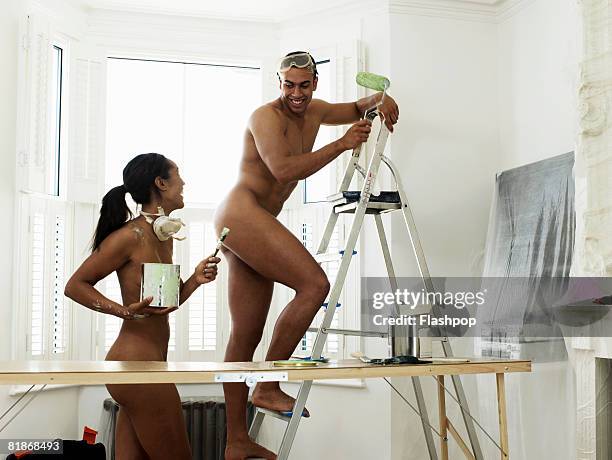 couple doing diy in the nude - step ladder stock-fotos und bilder