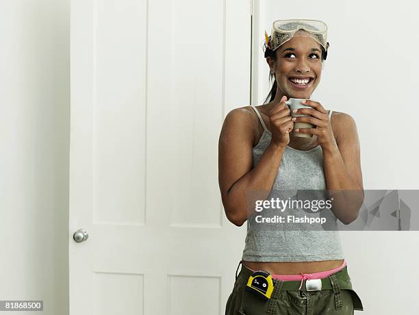 woman taking a break drinking a cup of coffee - safety glasses at home stock pictures, royalty-free photos & images