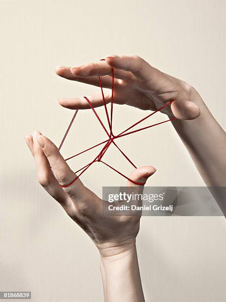 hands playing with a string - pelote de laine photos et images de collection