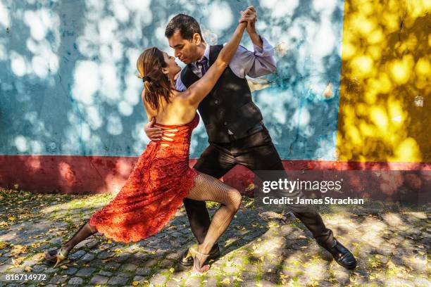 street tango dancers against colourful wall, el caminito, la boca, buenos aires (birthplace of the tango) argentina (model released) - tango argentina stock pictures, royalty-free photos & images