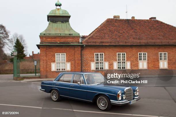Car pulling out of the Marmorpalais Gardens, known as the Neuer Gardens. The Palace was designed by Carl von Gontard and Carl Gotthard and is in the...