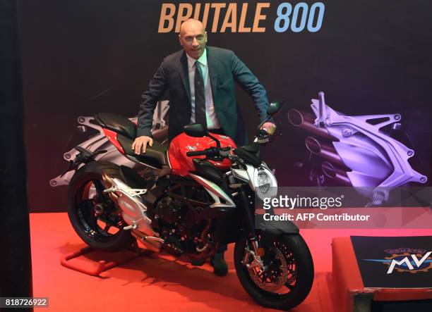 Raffaele Giusta, sales and marketing director of MV Agusta, poses with the Brutale 800 motorbike during its launch in Mumbai on July 19, 2017. / AFP...