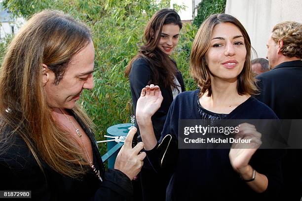 John Galliano sprays Sofia Coppola's wrists with eua de parfum as Bojana Panic looks on, during the launch party for John Galliano's new signature...