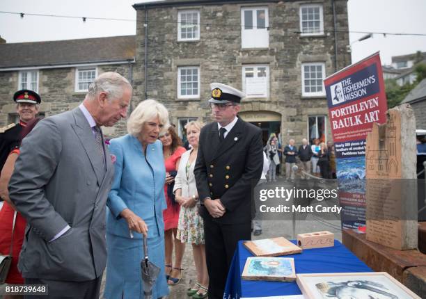Prince Charles, Prince of Wales and Camilla, Duchess of Cornwall, look at artwork that was made from wood salvaged from the storms in 2014 during an...