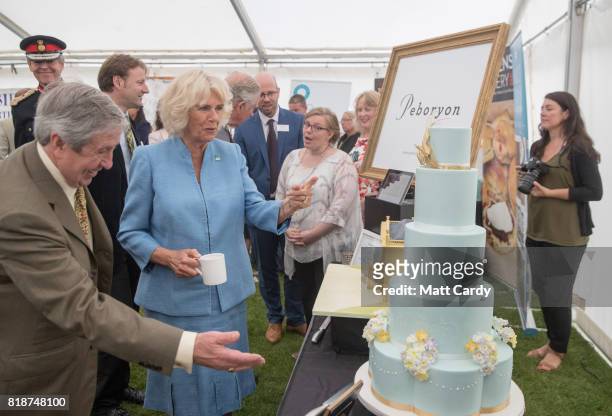 Camilla, Duchess of Cornwall, looks at a lemon and Cornish elderflower sponge cake, a 5 tier to represent the Duchess's wedding outfit made by...