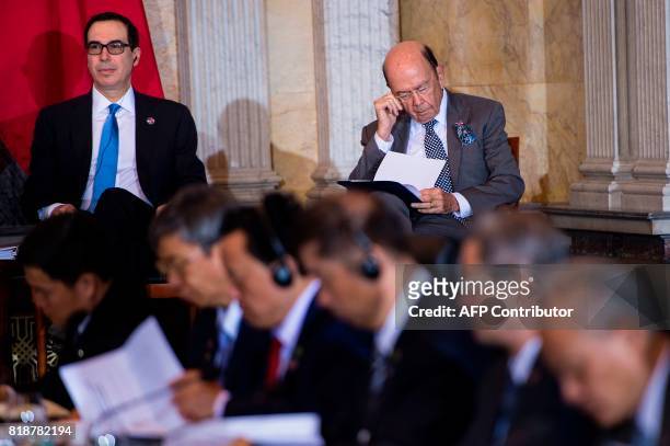 Secretary of the Treasury Steven Mnuchin and US Secretary of Commerce Wilbur Ross listen while China's Vice Premier Wang Yang speaks during a US and...