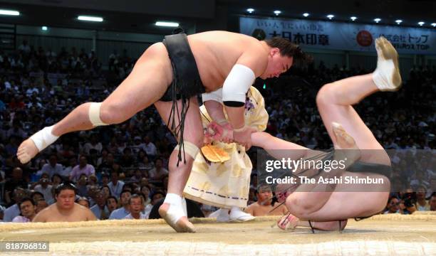 Mongolian yokozuna Harumafuji throws Mongolian wrestler Chiyoshoma to win during day eleven of the Grand Sumo Nagoya Torunament at Aichi Prefecture...