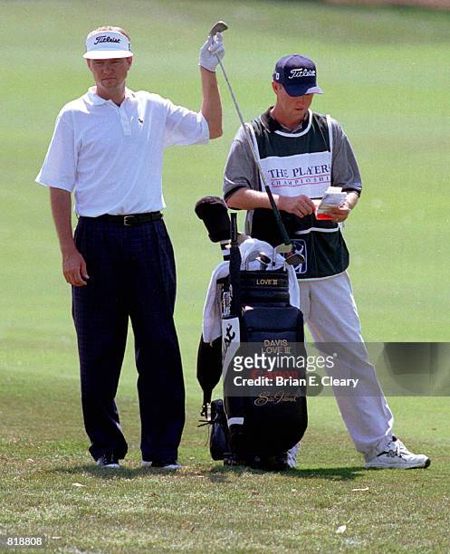 Golfer Davis Love III selects a club to hit a shot on the 9th fairway during the first round of The Players Championship in Ponte Vedra Beach,...