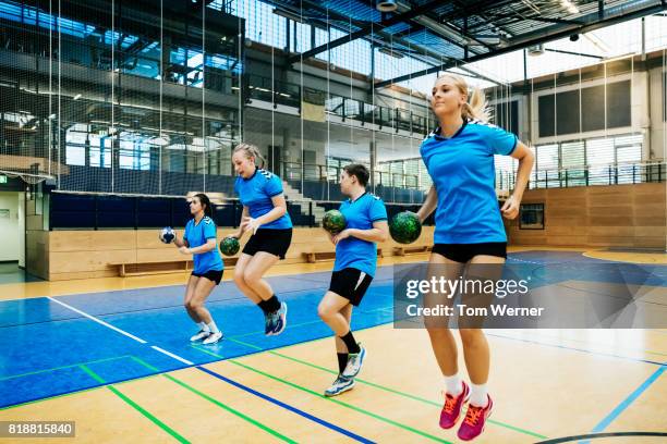 female handball team warming up - mannschaftssport stock-fotos und bilder