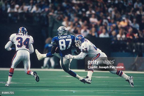 Tight end Carlester Crumpler of the Seattle Seahawks is hit by safety Steve Atwater of the Denver Broncos after making a catch at the Kingdome in...