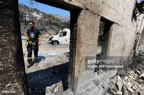 This photograph taken on July 19 shows a firefighter as he walks in a burnt-out house in the village of Zrnovnica, near the Adriatic coastal town of...
