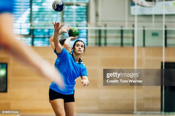 female handball player throwing ball - frontón fotografías e imágenes de stock