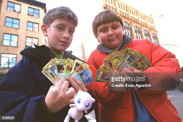 Two children display their Pokemon cards in New York city November 12, 1999. In anticipation of the overwhelming demand for the new limited edition...