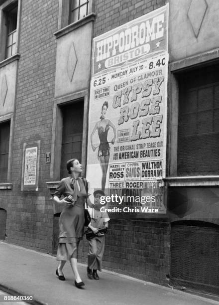 American entertainer Gypsy Rose Lee passes a poster advertising her show with her son Eric in Bristol, UK, 1951.