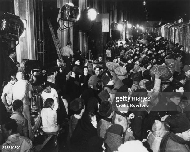 English film director David Lean is visible beneath the camera during the filming of a crowd scene for 'Doctor Zhivago' in Spain, 31st August 1965....
