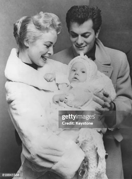 Married American actors Tony Curtis and Janet Leigh with their six-month-old baby daughter Kelly Curtis in New York, 26th November 1956.