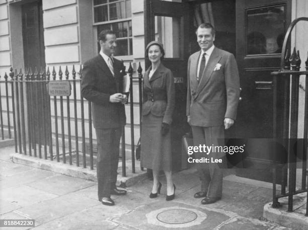 British actress Vivien Leigh and her husband, actor Laurence Olivier with playwright Terence Rattigan outside the Theatre Royal in London, 1953. They...