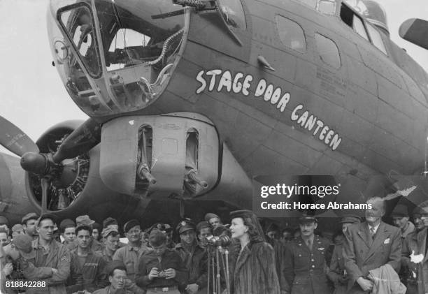 British actress Vivien Leigh speaks at the christening of US B-17 Flying Fortress 'Stage Door Canteen', watched by her husband, actor Laurence...