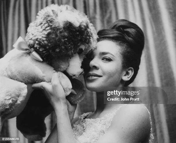 Welsh singer Shirley Bassey hugs a toy dog mascot before a show, December 1962.