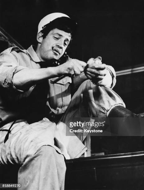 French actor Jean-Paul Belmondo peeling potatoes in his role as a French Foreign Legionary in the film 'Dragées au poivre' , directed by Jacques...