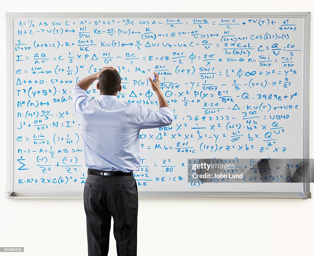 Man Overwhelmed In Front Of Large Math Problem