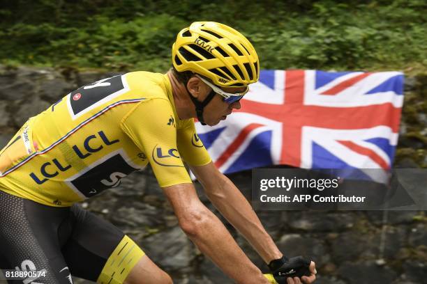 Great Britain's Christopher Froome, wearing the overall leader's yellow jersey, rides past an UK Union jack flag during the 183 km seventeenth stage...