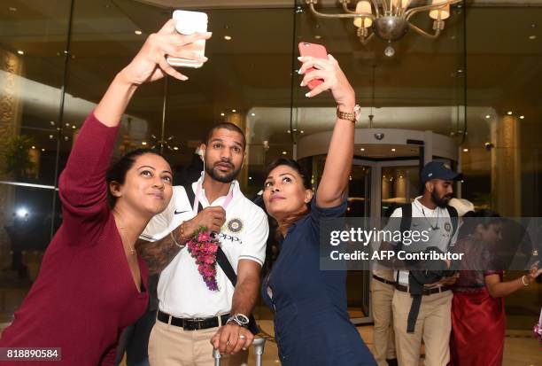 Indian cricketer Shikar Dhawan poses for a 'selfie' as he and teammates arrive at a hotel in Colombo on July 19, 2017. India and Sri Lanka will play...