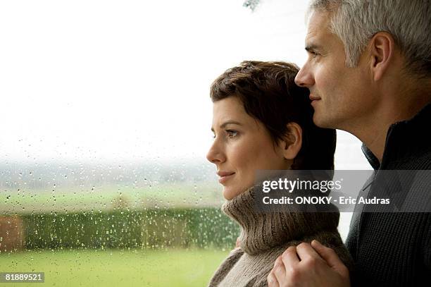 mature man and a mid adult woman looking out through a window - women's water polo bildbanksfoton och bilder