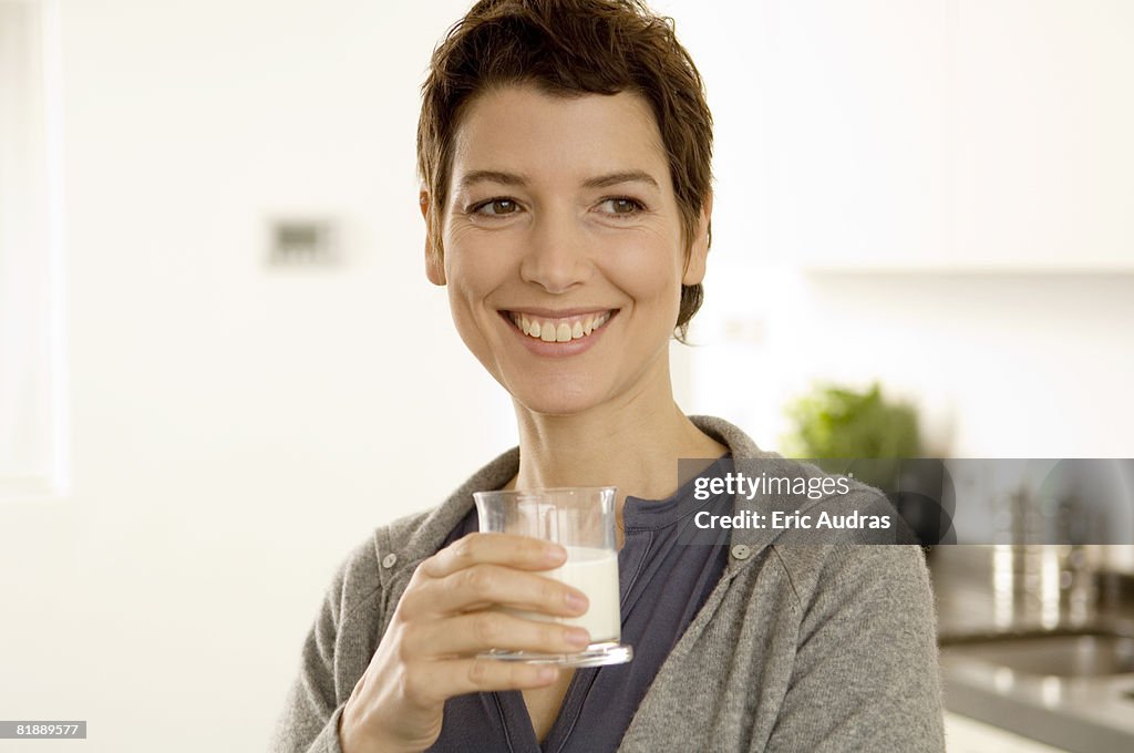Mid adult woman holding a glass of milk