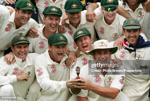 The Australian team including Matthew Hayden, Adam Gilchrist, Ricky Ponting, Shane Warne, and Justin Langer celebrate with a replica Ashes urn having...