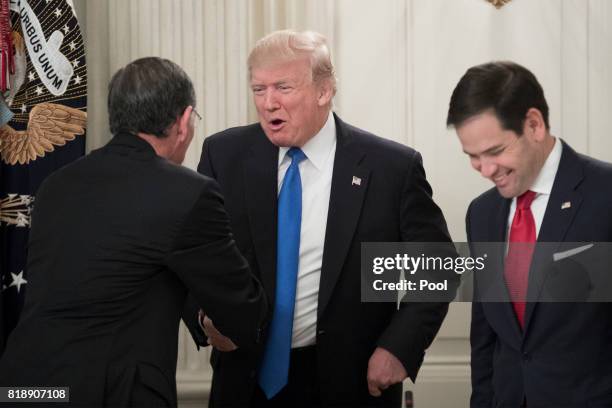 President Donald Trump shakes hands with Republican Senator from Wyoming John Barrasso , beside Republican Senator from Florida Marco Rubio ; at a...