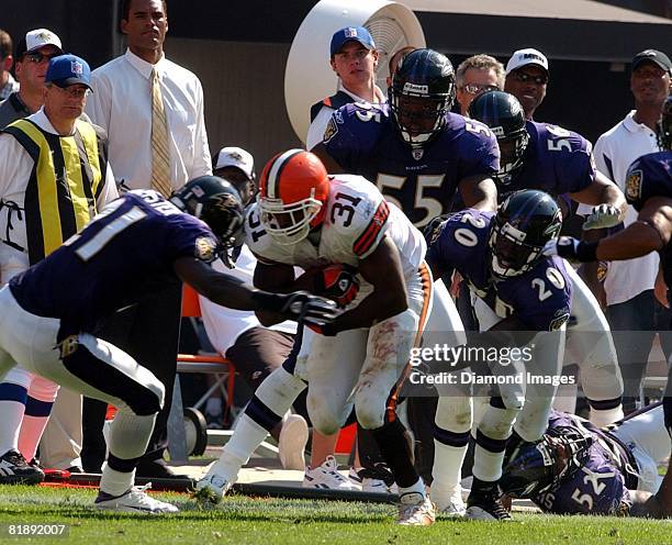 Running back William Green of the Cleveland Browns is tackled by defensive back Chris McAllister, linebacker Terrell Suggs, and safety Ed Reed of the...