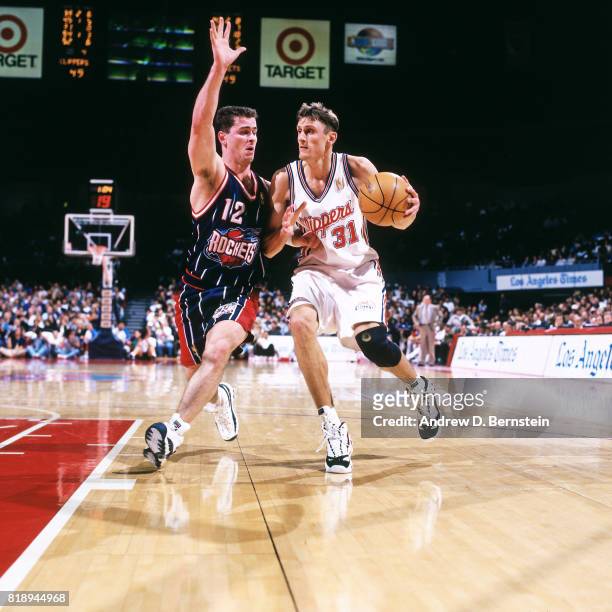 Brent Barry of the Los Angeles Clippers drives against Matt Maloney of the Houston Rockets during a game at the Los Angeles Memorial Sports Arena in...
